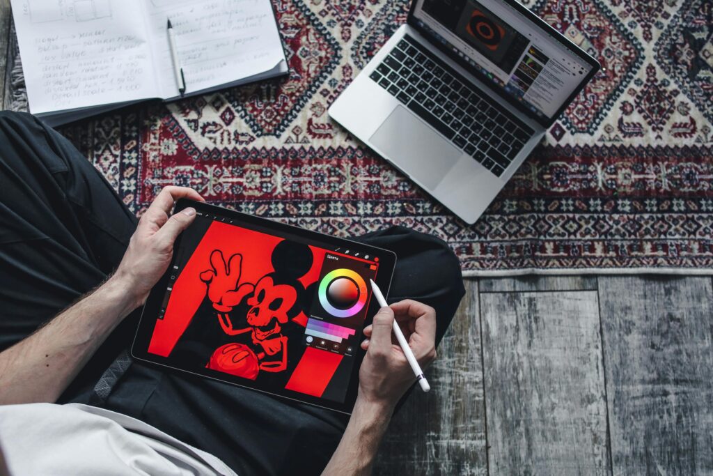 person holding a tab with a mickey mouse drawing